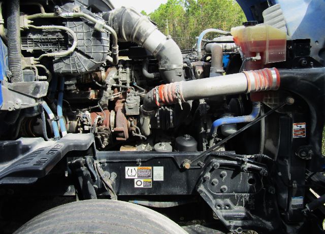 Kenworth T680 engine bay showing radiator hoses and intake manifold, coolant reservoir, and engine components.