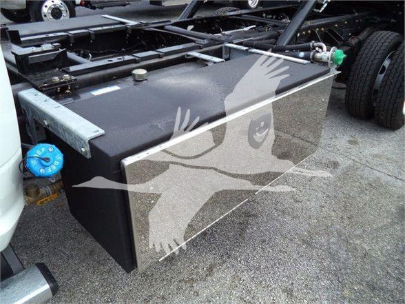 Ram 5500 chassis with large rectangular fuel/utility tank mounted behind cab, blue coolant cap on left, various hoses and metal brackets visible.