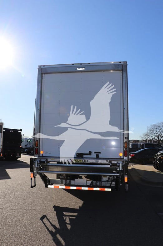 Isuzu box truck rear showing closed cargo door with graphic bird design and rear underride guard.
