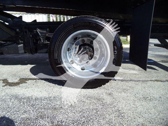 Wheel hub and leaf suspension of a 2023 Chevrolet Silverado 6500HD chassis showing chrome wheel with lug nuts and brake components.