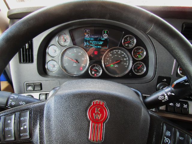Kenworth T680 cockpit dashboard with multiple gauges and digital display.