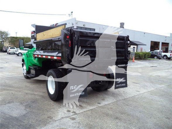 Ford F650 SD dump truck in profile view showing dump bed and rear end, green cab and black dump mechanism.