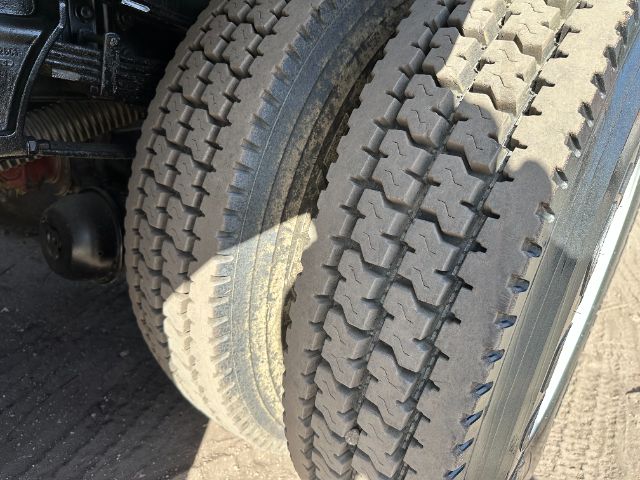 Dual rear wheels with heavy tread tires on a truck, part of a vacuum service vehicle; visible components include wheel assemblies and suspension near the tires.