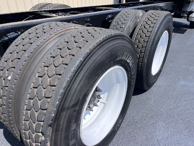 Truck rear wheels and dual axle setup with heavy-duty tires on FREIGHTLINER M2 chassis. visible text includes tire sidewall markings.