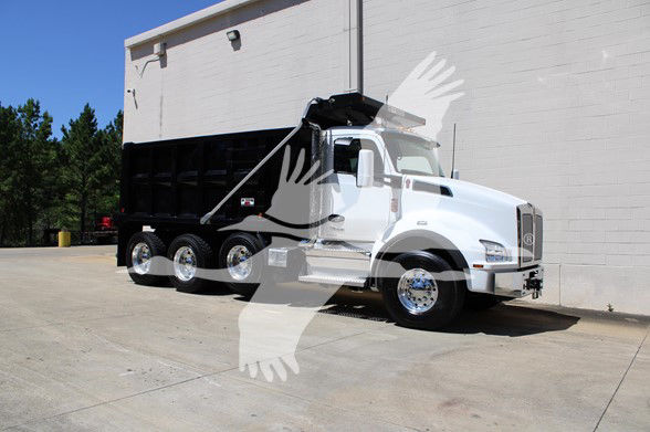 Kenworth T880 dump truck in white with black dump box, side view, parked on concrete near a building.
