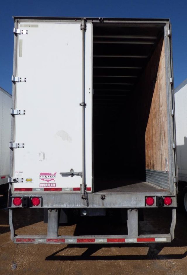 Rear of a white 2014 Wabash dry van trailer with open cargo area, wooden interior, and red taillights.