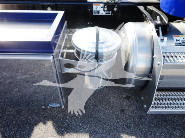Peterbilt 337 truck engine bay area showing a circular air filter housing and metal intake components beside a chrome step with diamond plate pattern.