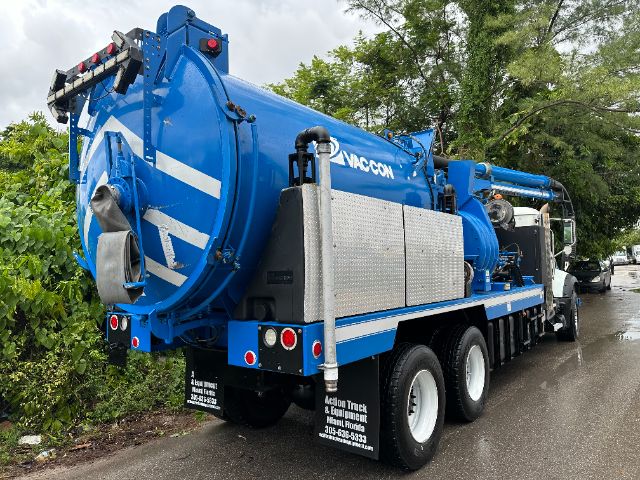 Mack GU713 vacuum truck in blue with white decals, rear view showing hose reel and tank
