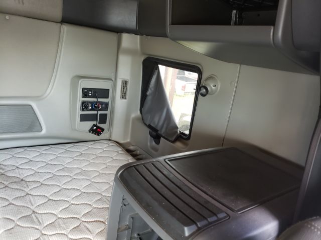 Truck sleeper cab interior showing window, control panel, and quilted sleeper mattress in a 2015 International ProStar.