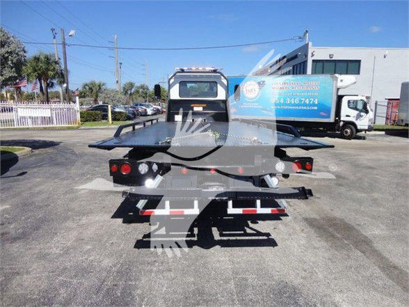 Truck bed with flatbed/tow equipment visible from rear, tail lights, and bumper.