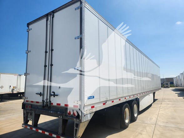 A 2019 Stoughton van trailer in a parking lot showing aluminum sides, rear doors, and dual rear wheel axles.