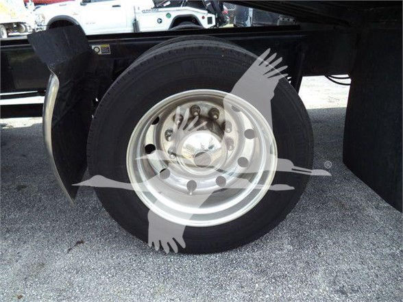 Kenworth T370 wheel and tire on a tow truck chassis undercarriage showing single steel wheel and black fender.