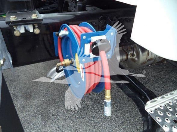 Tow truck equipment: a blue hose reel mounted on a black chassis with red hoses and brass fittings.