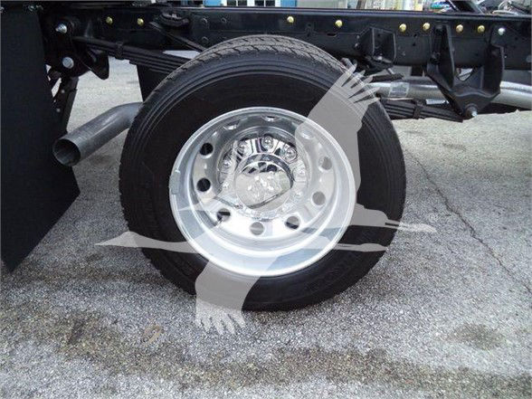 Wheel and suspension of a 2024 Ram 5500 SLT truck showing a polished steel wheel and tire on a chassis with frame rails.