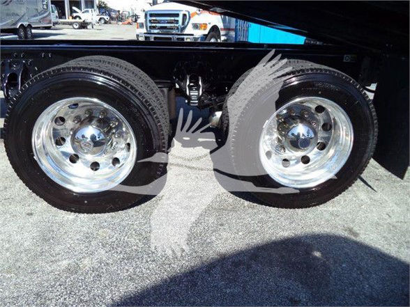 Two large chrome wheels and dual rear axles of a Kenworth T880 truck frame.