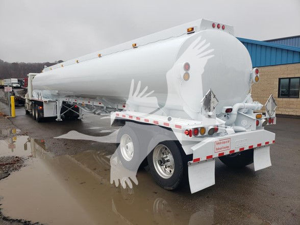 Tank trailer showing 9200 gallon trough bottom petro tank atlas Heil brand with rounded rear, dual wheels, and safety lights.