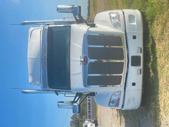 Peterbilt 579 conventional sleeper truck front view with chrome exhaust stacks and grille details.