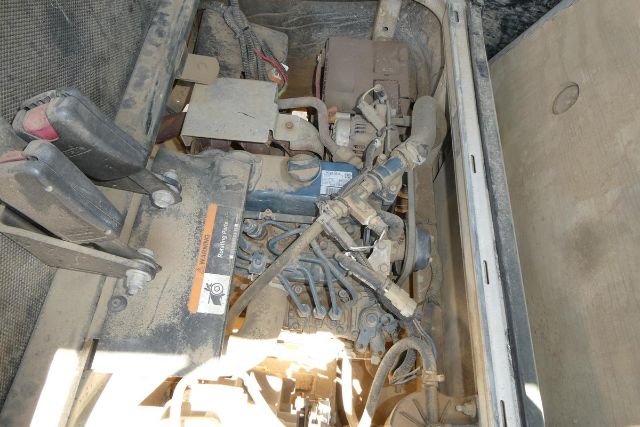Clubl Car Carryall 1700 engine bay showing label and hydraulic lines with dusty components.