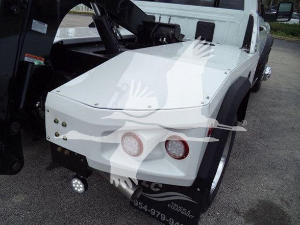 Ram 4500 tow truck rear deck with white body panels and taillights visible, showing flatbed area and wheel fender