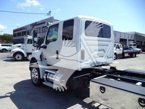 International MV tow truck cab rear and side view showing white exterior, dual side mirrors, and chassis with flatbed equipment.