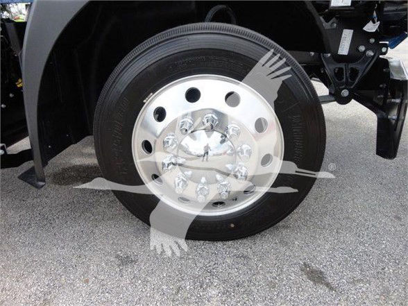 Wheel and hub of a 2025 Mack MD6 truck front axle showing polished hubcap with multiple lug nuts on a black tire.