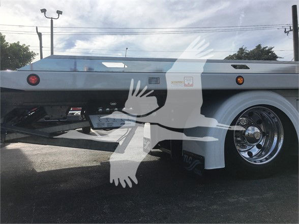 2022 Peterbilt 337 tow truck side view showing chrome rear wheel, white body, fuel tank, and undercarriage components.