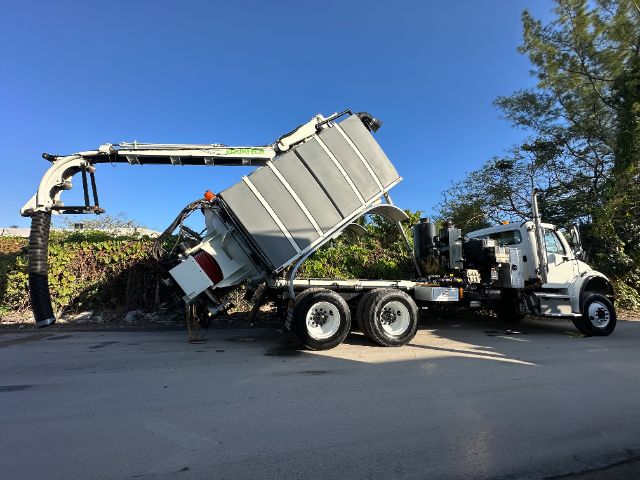 Concrete mixer truck in service showing raised mixer hopper and truck cab.