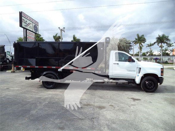 2023 Chevrolet Silverado 6500HD refuse truck side view showing white cab and black dump body.