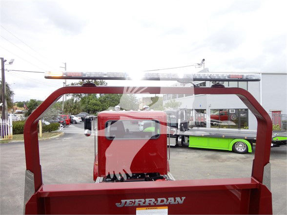 Truck bed with red Jerr-Dan tow truck body and light bar; rear view shows branding and equipment mounting.