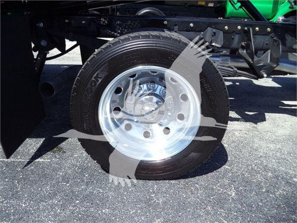 Truck wheel and front suspension of a 2024 Ram 5500 SLT showing a polished steel wheel and tire, with part of the chassis and undercarriage visible.