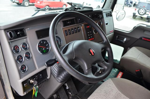 Kenworth T370 dashboard and steering wheel inside cab with gauges and controls visible.