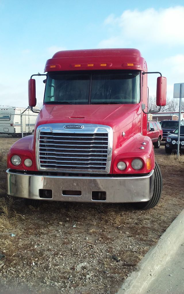 Freightliner conventional sleeper truck front view showing large chrome grille, red cab, and chrome bumper.