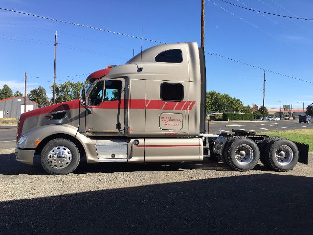 2012 Peterbilt 578 conventional sleeper truck side view showing cab with red stripe and dual rear axles.