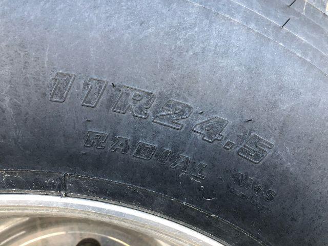 Tire sidewall showing 11R24.5 radial tires on Load King PF 948 oilfield flat deck trailer.