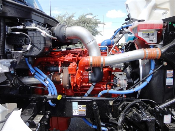Kenworth W900 engine bay showing red engine, blue coolant lines, silver turbo piping, and various hoses.