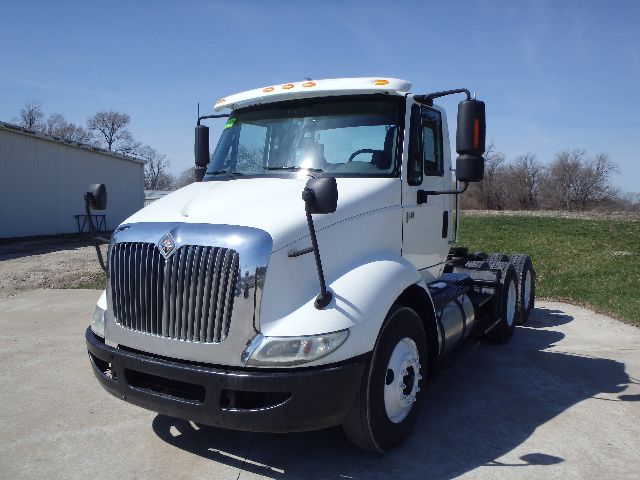 Truck showing front and side of a white 2007 International 8600 conventional daycab with chrome grille and dual rear tires.