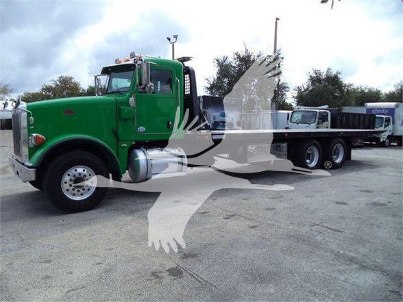 Green Peterbilt 367 tow truck with a flatbed, side view showing cab and long wheelbase.