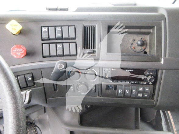 Volvo truck interior dashboard showing controls, ignition area, gear selector with PRNDM, and radio/display.