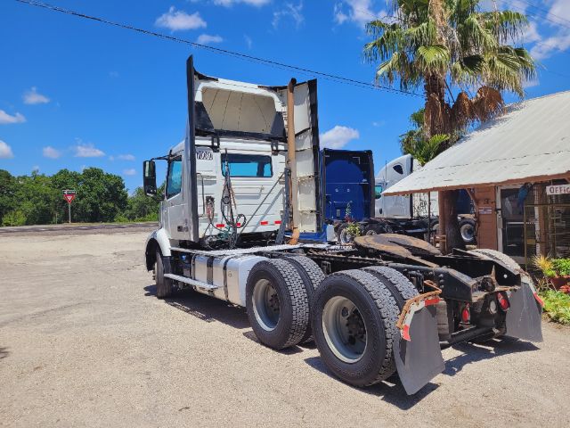 Volvo VNR daycab rear view showing chassis and dual rear axles with fifth wheel and cab open at back, daytime outdoor lot.