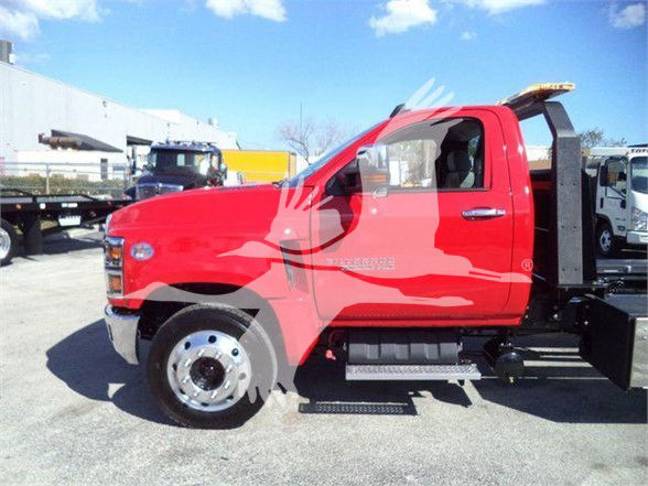 Chevrolet Silverado 6500HD tow truck cab side view showing red body, black steps, and mounted equipment.