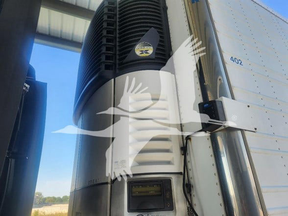 Utility 3000R trailer refrigeration unit with door panel and HVAC fins, showing a small display at lower front and the number 402 on the side.