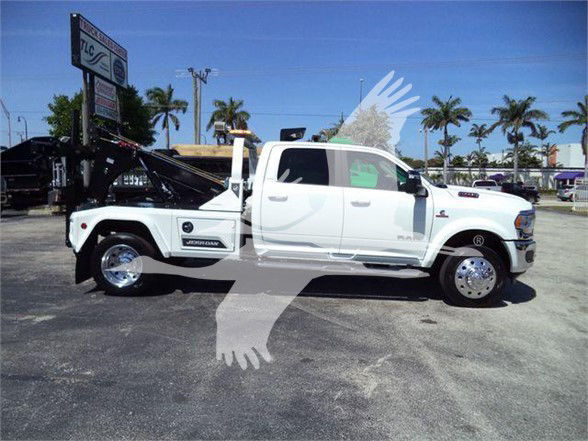 2024 Ram 5500 Laramie white tow truck side view with extended cab and dump bed, branding visible on doors and wheel covers.