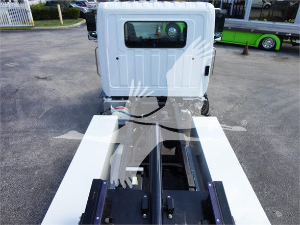 Rear view of 2022 Hino 268A tow truck chassis showing flatbed and wheel wells, with a white cab and hydraulic components visible.