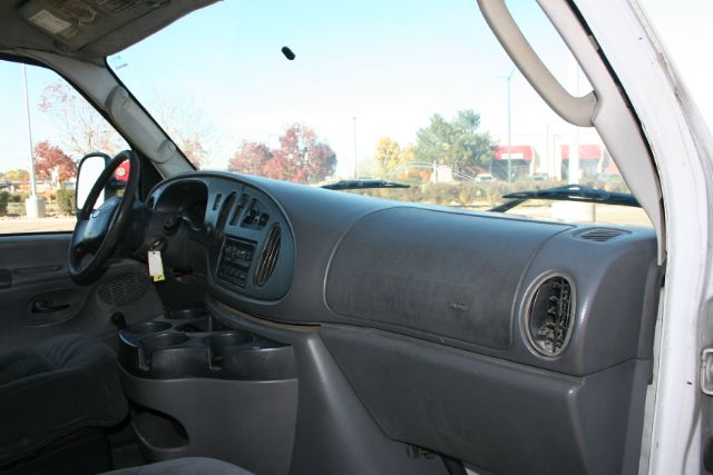 2005 Ford E350 interior dashboard and driver area with steering wheel, center console, and passenger-side air vent