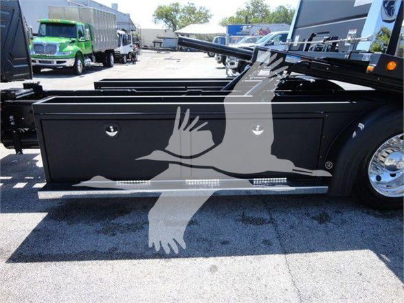 Truck side panel with storage compartments and a graphic watermark of a bird. No legible model text visible on the panel.