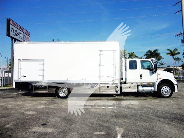 Tow truck side view showing a large white box body and cab of a 2022 International MV with stock number J93674.