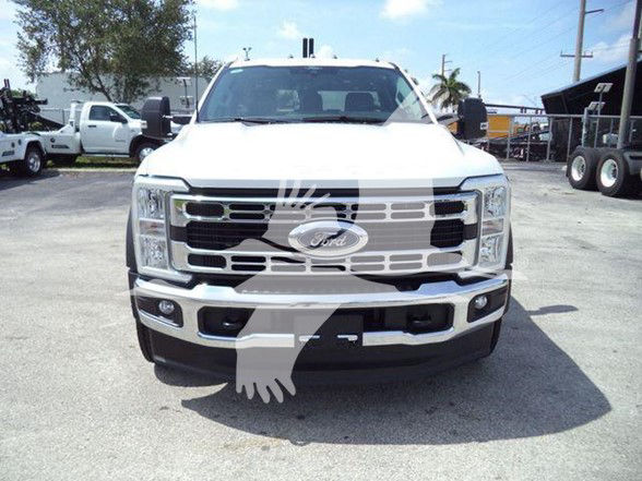 Front view of a white 2024 Ford F-450 truck with large grille and bumper, Ford emblem visible, daytime outdoor dealership lot.