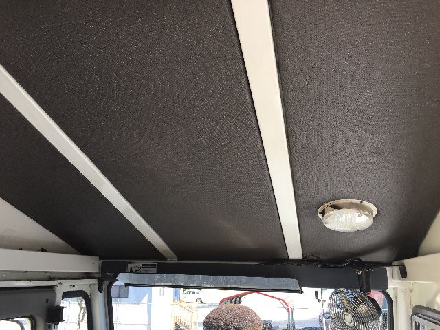 Interior of 2013 Kalmar Ottawa YT30 yard truck cab ceiling with black textured panels and a circular ceiling light.