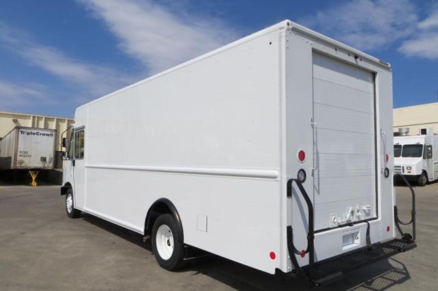 Ford F-59 box truck with a white cargo body, rear doors, and a ramp. No visible branding on sides.