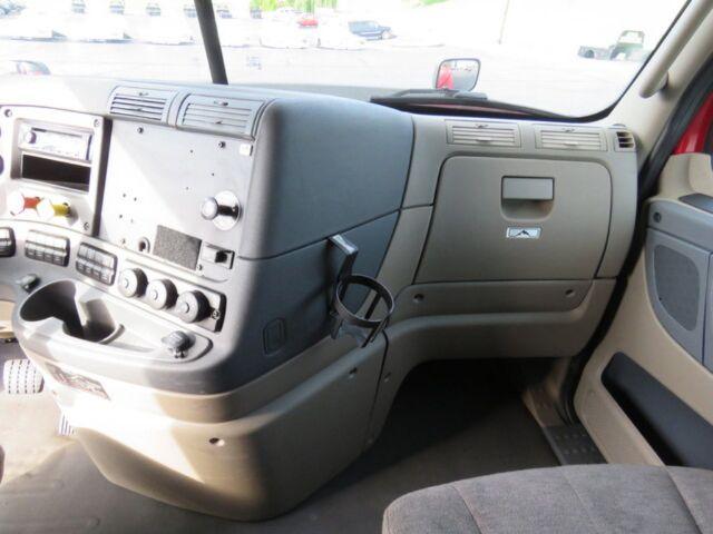 Freightliner Cascadia Evolution truck interior dashboard and passenger side; center console with climate controls, radio slot, and cup holder.